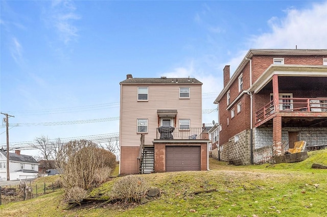 back of property with a garage and a lawn