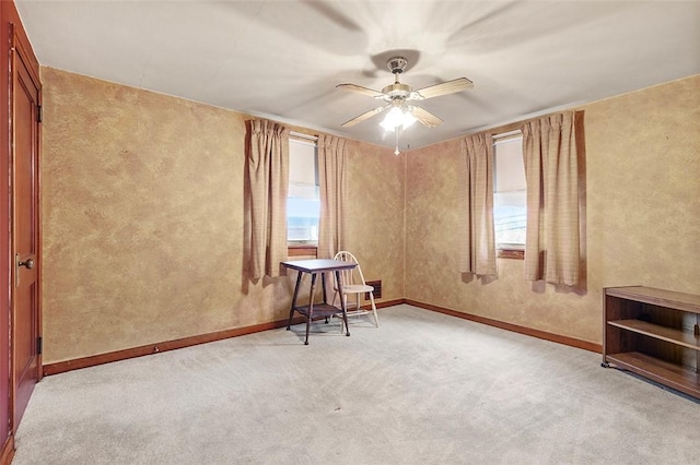 carpeted spare room featuring ceiling fan