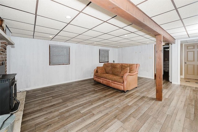 interior space featuring hardwood / wood-style flooring, a paneled ceiling, and a wood stove