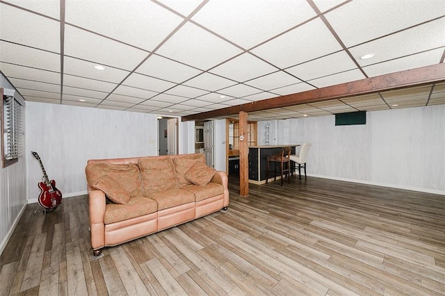 living room featuring a paneled ceiling and wood-type flooring