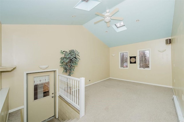 interior space with ceiling fan and lofted ceiling with skylight