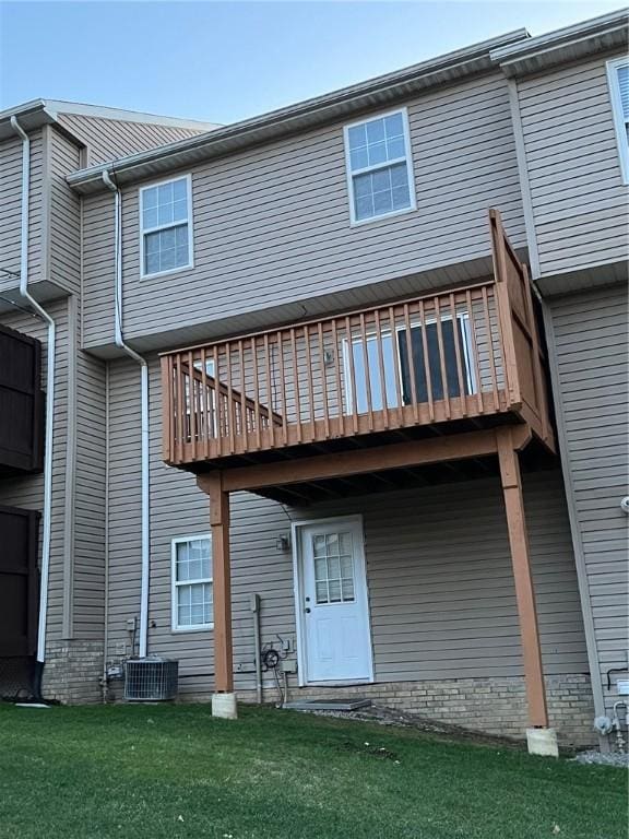 back of property with a wooden deck, a yard, and central air condition unit