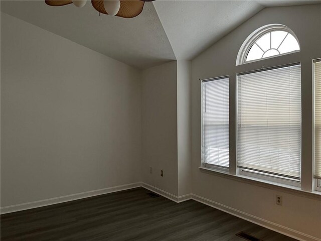 empty room with ceiling fan, lofted ceiling, and dark hardwood / wood-style flooring