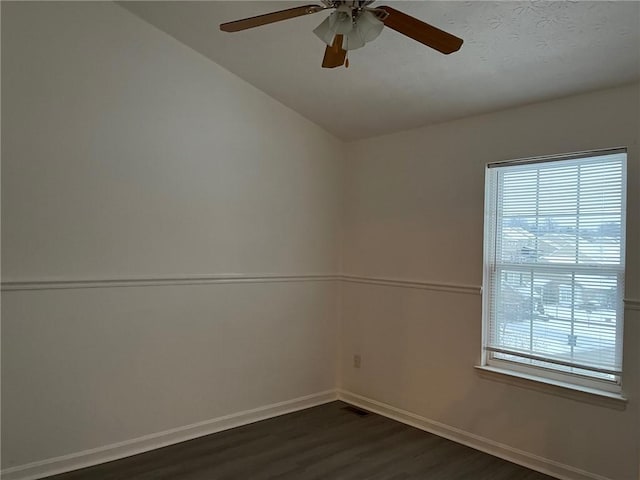 spare room with dark hardwood / wood-style flooring, a wealth of natural light, lofted ceiling, and ceiling fan