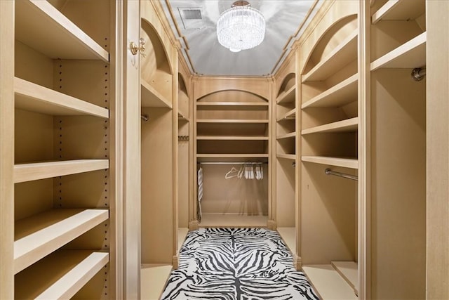 spacious closet featuring a chandelier