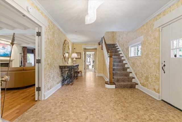 foyer entrance featuring hardwood / wood-style floors, a wealth of natural light, and ornamental molding