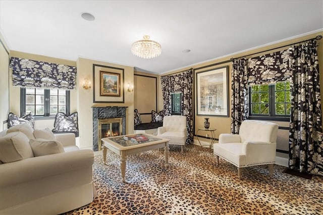 living room with an inviting chandelier, ornamental molding, and a fireplace