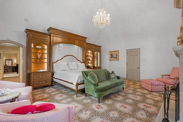 bedroom with a towering ceiling, light colored carpet, and an inviting chandelier