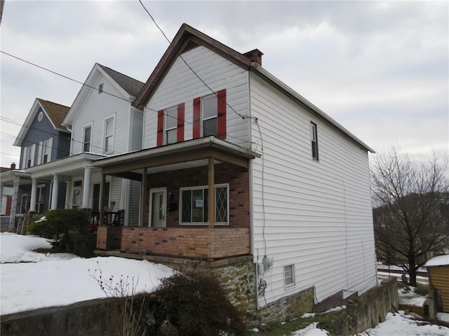 snow covered property featuring a porch