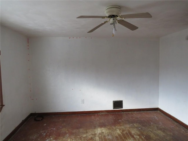 empty room with a ceiling fan, wood-type flooring, visible vents, and baseboards