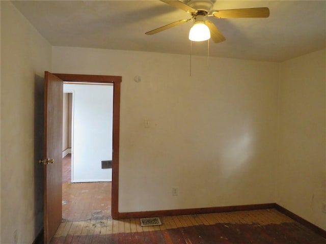 spare room with a ceiling fan, baseboards, visible vents, and hardwood / wood-style floors