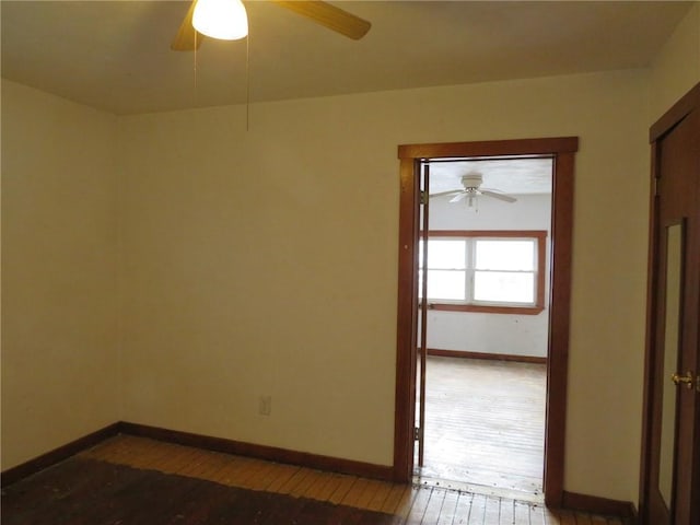 empty room with a ceiling fan, baseboards, and hardwood / wood-style floors