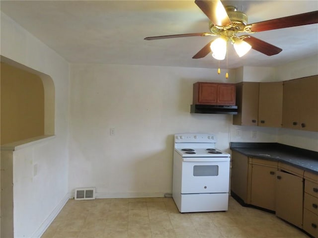 kitchen featuring dark countertops, visible vents, electric range, under cabinet range hood, and baseboards