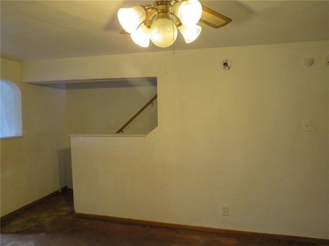 empty room featuring ceiling fan and baseboards