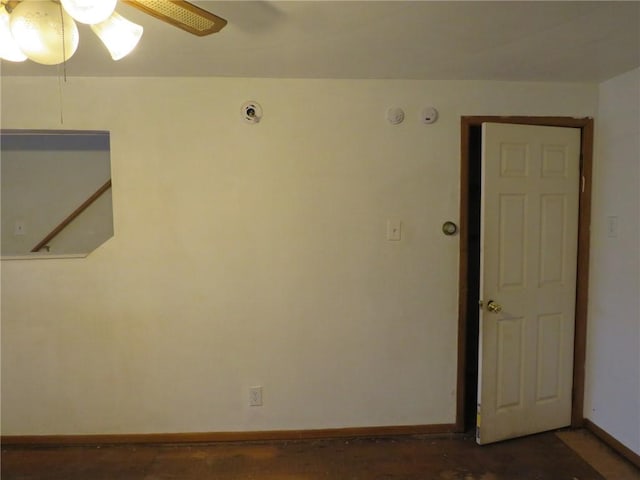 empty room featuring ceiling fan and baseboards