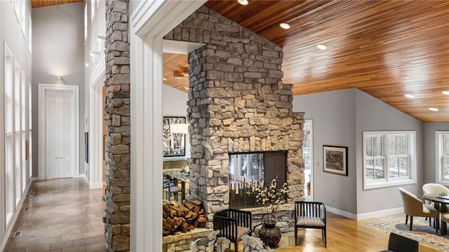 living room featuring high vaulted ceiling, wood ceiling, baseboards, and a multi sided fireplace