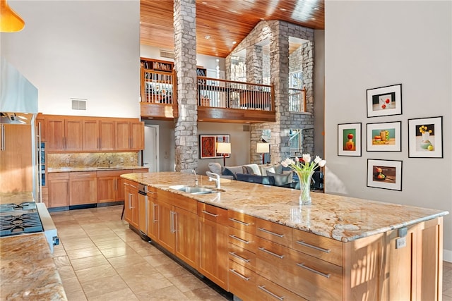 kitchen featuring a high ceiling, a sink, visible vents, wood ceiling, and ornate columns