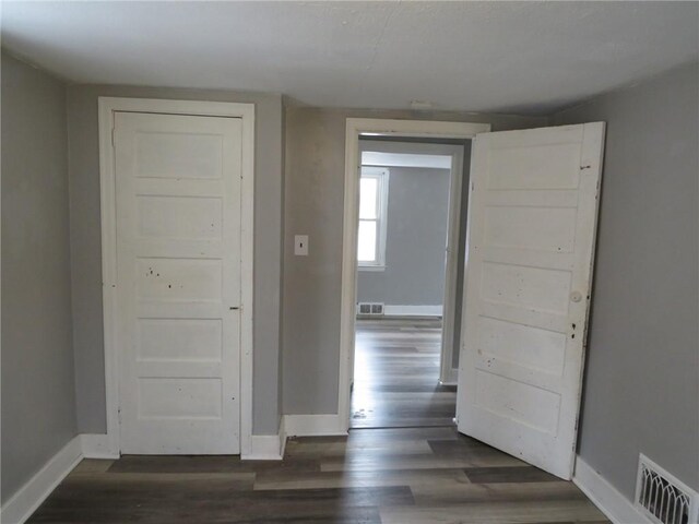 corridor with dark hardwood / wood-style flooring