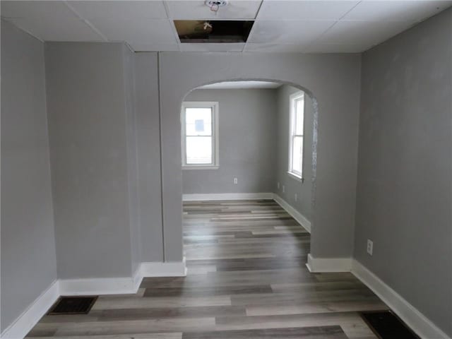 unfurnished room featuring visible vents, baseboards, and wood finished floors