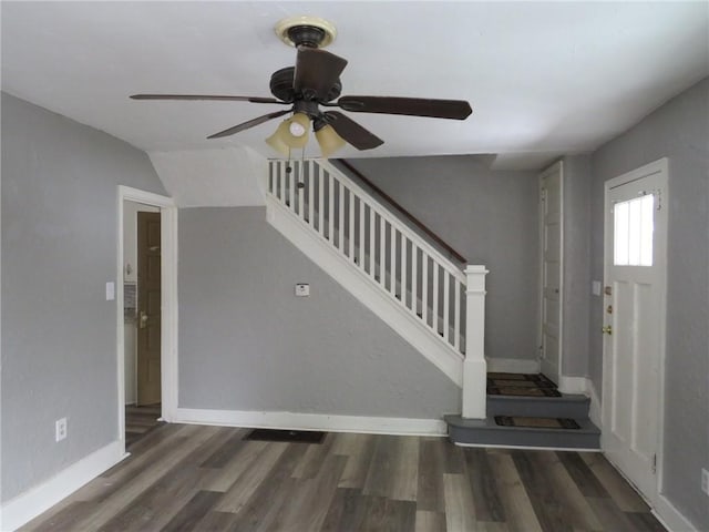 foyer entrance with a ceiling fan, wood finished floors, baseboards, and stairs