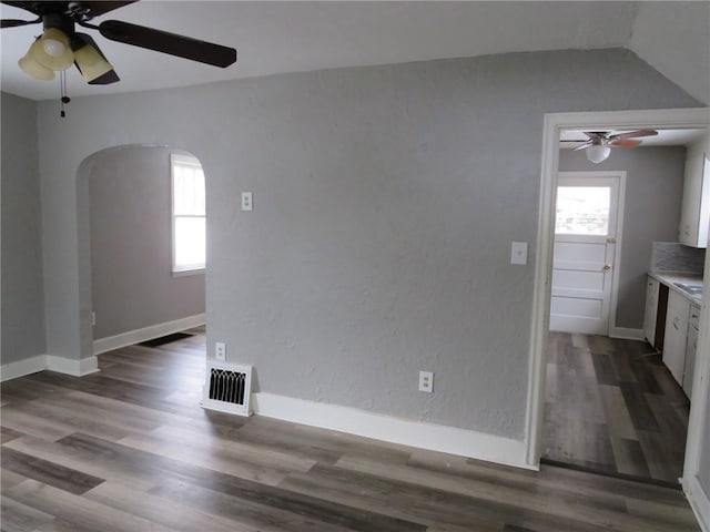 interior space featuring ceiling fan, dark hardwood / wood-style floors, and a healthy amount of sunlight