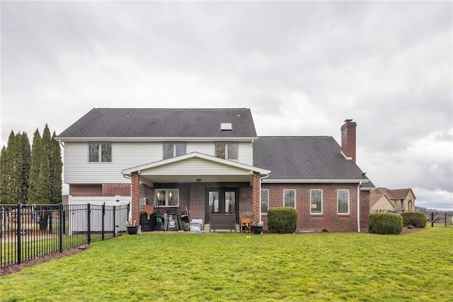 rear view of property with a yard and a patio area