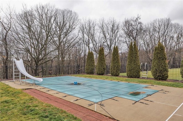 view of swimming pool with a patio area, a lawn, and a water slide