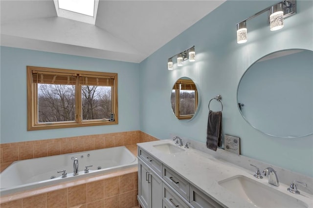 bathroom featuring a relaxing tiled tub, vanity, and lofted ceiling with skylight