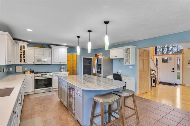 kitchen featuring white cabinetry, a kitchen bar, a center island, and appliances with stainless steel finishes