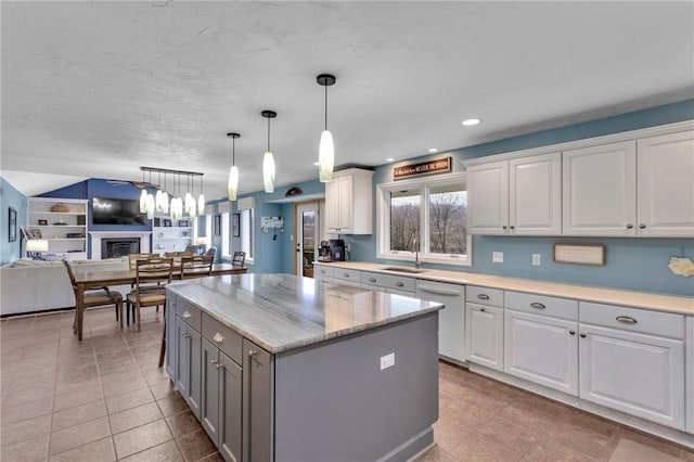 kitchen with a center island, white dishwasher, decorative light fixtures, and white cabinets