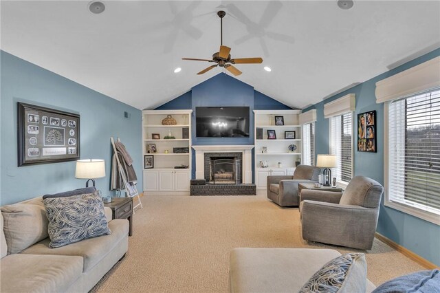 living room with vaulted ceiling, carpet floors, ceiling fan, and a fireplace