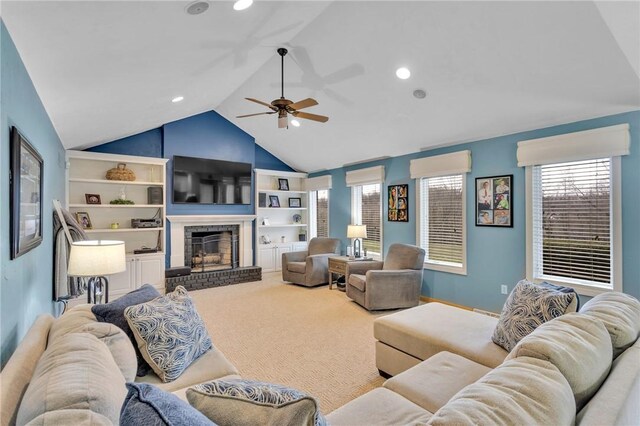 carpeted living room featuring built in shelves, a fireplace, ceiling fan, and vaulted ceiling