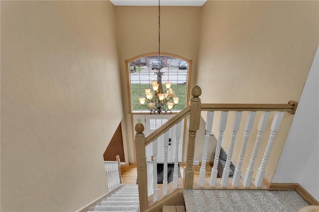 stairs with a towering ceiling and a notable chandelier