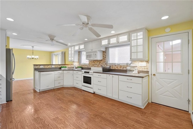 kitchen with white cabinetry, light wood-type flooring, pendant lighting, and white appliances