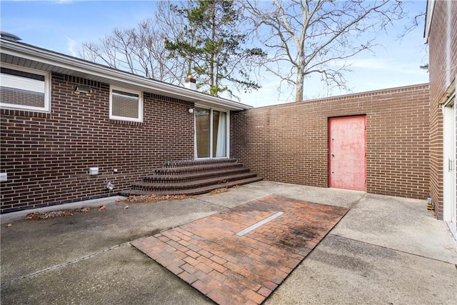 view of exterior entry featuring a patio area