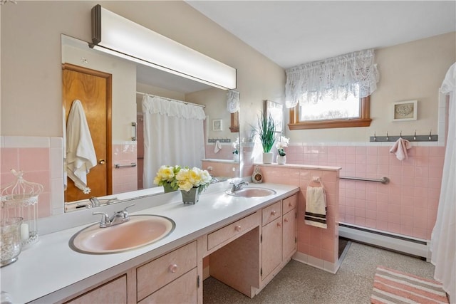 bathroom featuring baseboard heating, vanity, and tile walls