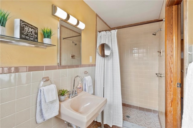 bathroom featuring tile walls, sink, and curtained shower