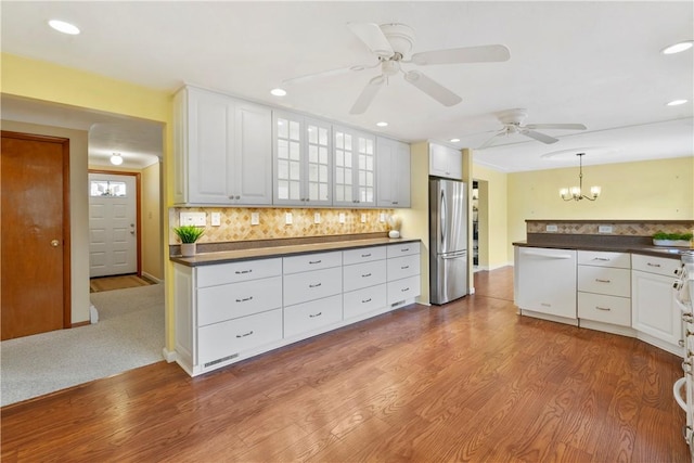 kitchen featuring white cabinetry, tasteful backsplash, light wood-type flooring, stainless steel fridge, and dishwasher