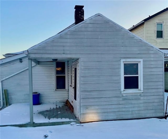 view of snow covered rear of property