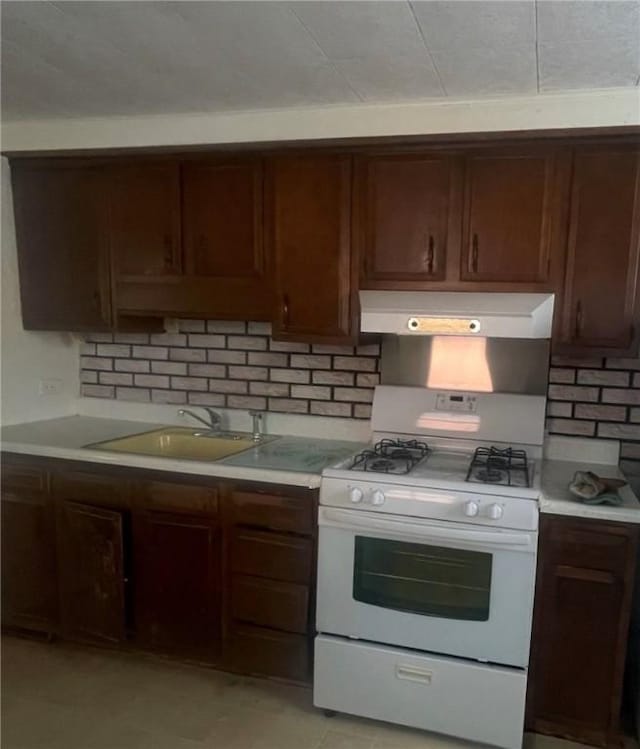 kitchen with tasteful backsplash, sink, and white gas range oven