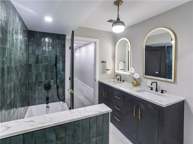 bathroom featuring tiled shower / bath combo and vanity