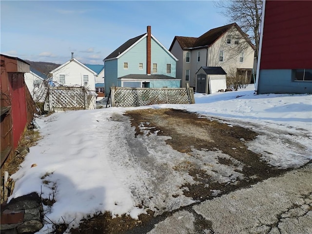 yard covered in snow with a storage shed