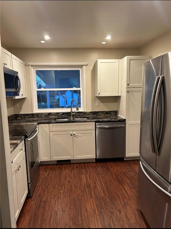 kitchen featuring white cabinetry, appliances with stainless steel finishes, sink, and dark wood-type flooring