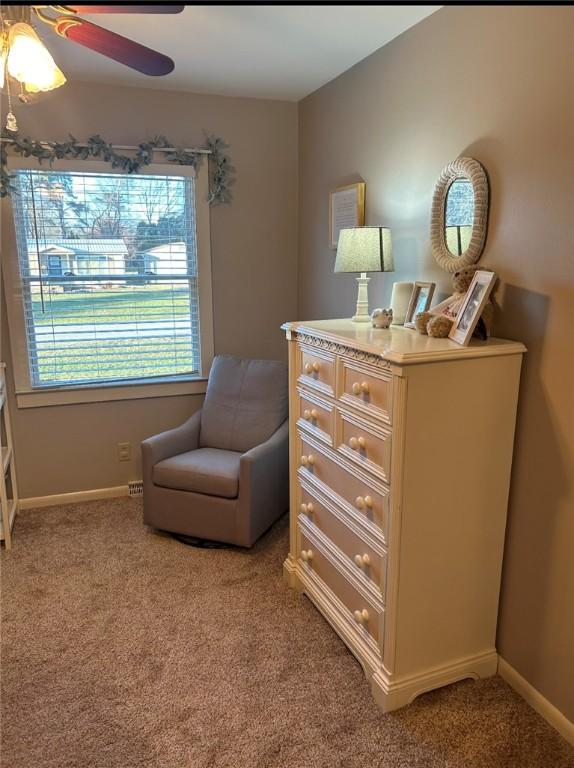 living area featuring carpet and ceiling fan