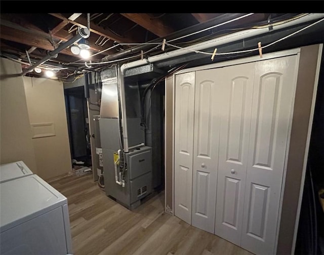 basement featuring hardwood / wood-style floors and heating unit