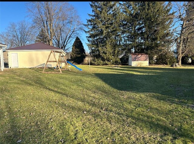 view of yard featuring a playground and a storage unit