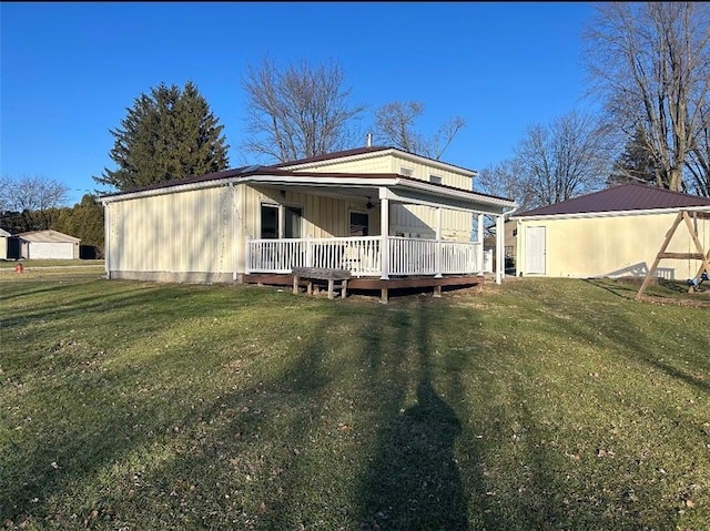 rear view of property featuring a yard and a porch