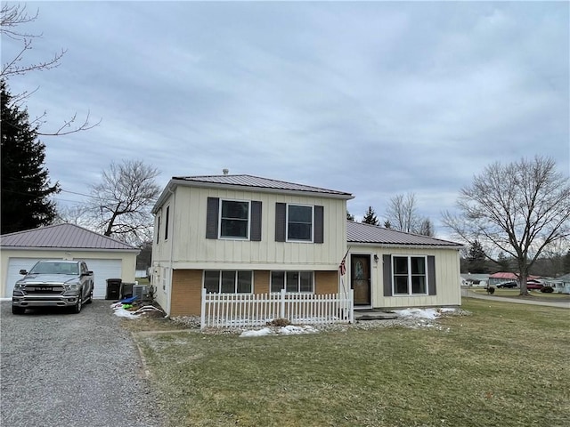 tri-level home with an outbuilding, a garage, and a front lawn