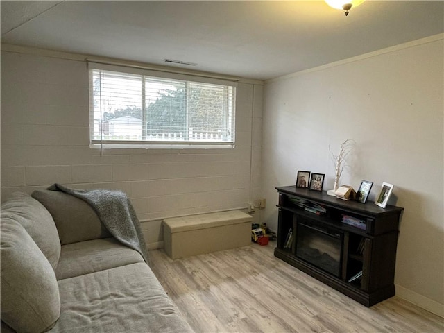 sitting room with crown molding and light wood-type flooring