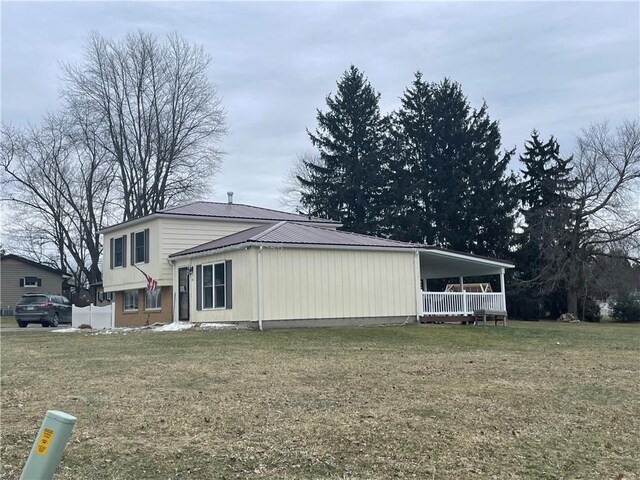 view of side of home featuring a porch and a yard